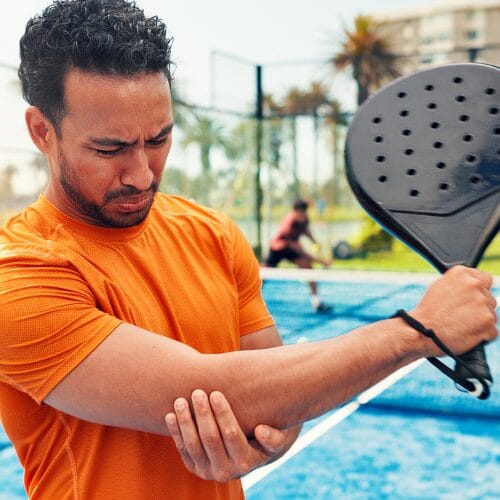 Active person holding elbow after pickleball